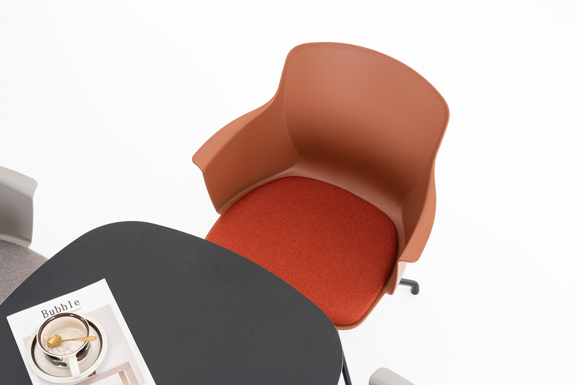 Terracotta lounge chair beside a dark round table