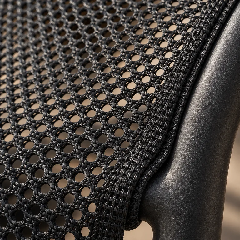 Close-up of tensioned woven seating mesh secured around a dark curved support frame.